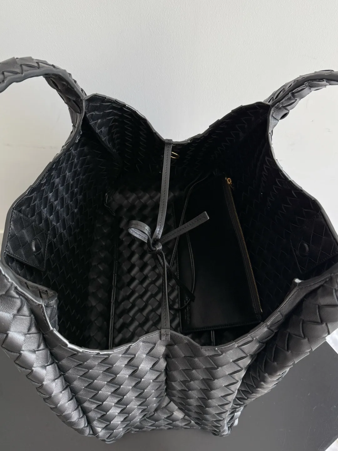 Batch 2760 new products are coming! BOTTEGA VENETA Bottega Veneta's 2025 new Campana shoulder bag is on the market~ First of all, I would like to praise the weight of this bag. As a not too small bag, it is very light for daily use. For people like me who need to carry a lot of belongings when going out, this advantage is great, and it greatly reduces the burden of traveling. 🛍️The shape is a bit like a combination of parachute and jodie. The blunt triangle shape is cute and honest. Carrying it on your back when going shopping is a good mood accelerator. The handles and body of the bag are both classic weaves. A tie is added to the original open design. If it is not tied up, the bag will look like a small vegetable basket when carried. Style number: 844250 Size: 39*24*18.5cm
